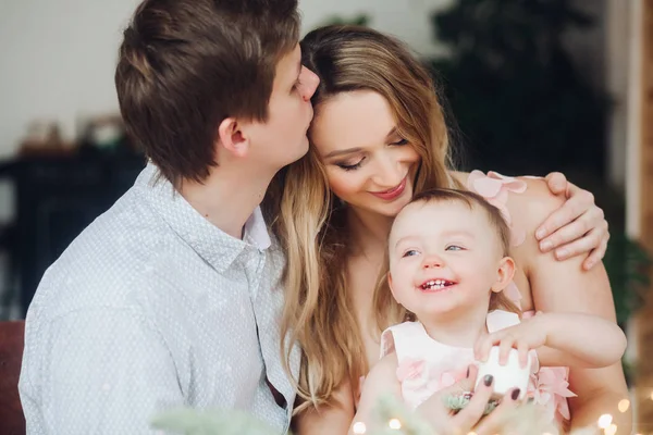 Pai beijando bela esposa loira, que segurando as mãos pequena filha bonito . — Fotografia de Stock