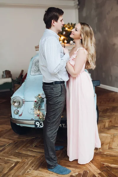 Lovely husband embracing beautiful blonde woman wearing pink dress. — Stock Photo, Image