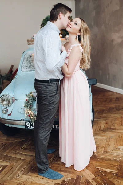 Lovely husband embracing beautiful blonde woman wearing pink dress. — Stock Photo, Image