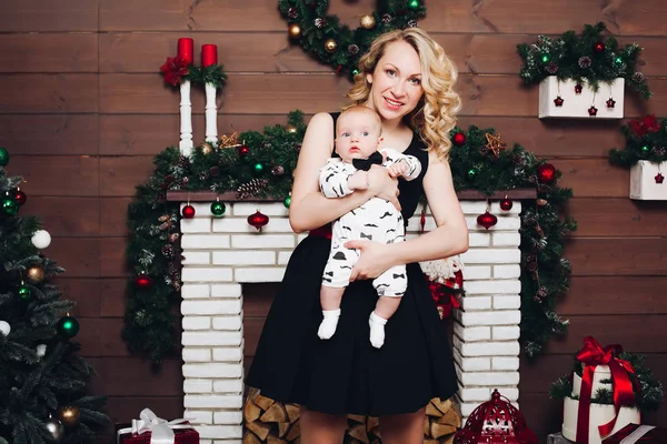 Menino com bela mãe loira abraçando no estúdio decorado para o Natal . — Fotografia de Stock