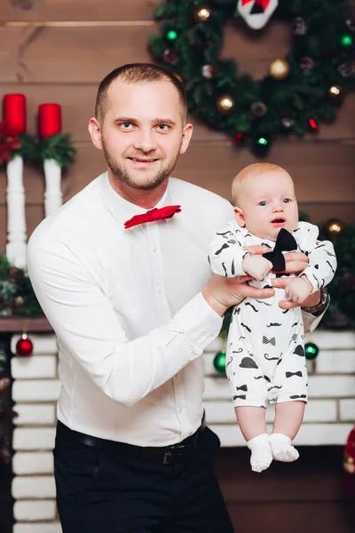 Guapo feliz padre en camisa blanca y corbata sosteniendo pequeño hijo por las manos . —  Fotos de Stock