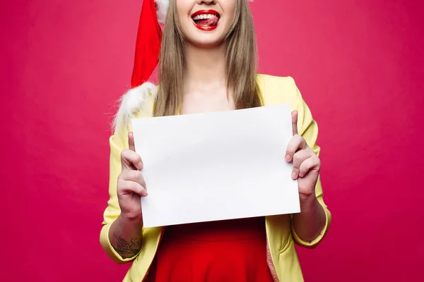 Leende flicka tomt pappersark i santa hatt. — Stockfoto