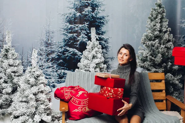 Atractiva mujer en vestido de punto con regalo de Navidad en el banco c — Foto de Stock