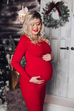 Duygusallık pregant kadın mide ayakta karşı bir şekilde dekore edilmiş ev kucaklayan.