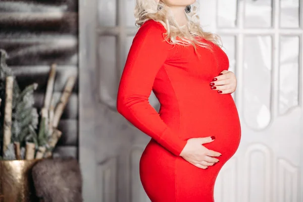 Урожай блондинки вагітної жінки в модному червоному платті, що приховує шлунок . — стокове фото