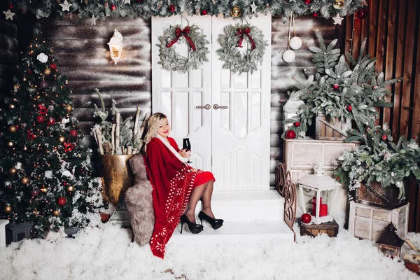 Sarışın merdivenlerde oturan asma bardak ile Noel için dekore edilmiş. — Stok fotoğraf