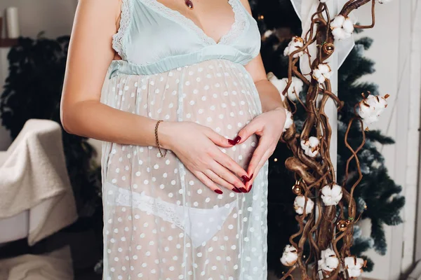 Mulher grávida irreconhecível com as mãos em forma de coração na barriga . — Fotografia de Stock
