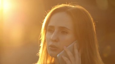 Çekici kadın parlak gün ışığı altında sohbet cep telefonu üzerinden.