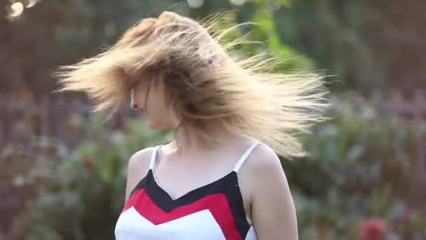 Šťastná dívka si hraje s její vlasy na slunečný večer. — Stock video
