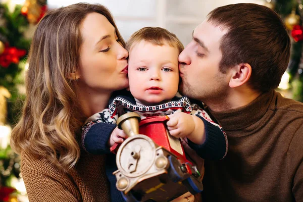 Padres cariñosos besar hijo celebración juguete tren . —  Fotos de Stock