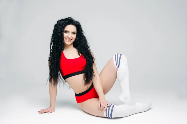 Portait of sexy dark haired girl in red sports wear. — Stock Photo, Image