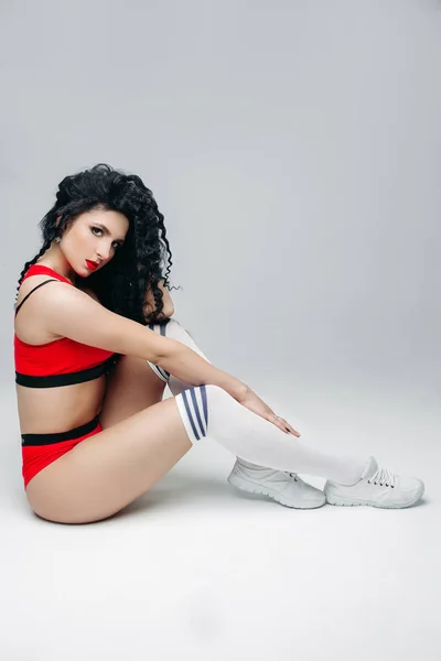 De brunette model sexy swag op witte sokken poseren in studio. — Stockfoto
