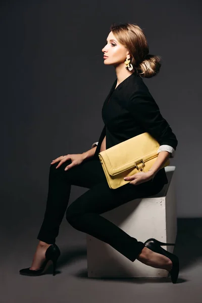 Mulher grávida elegante sentado contra fundo estúdio preto . — Fotografia de Stock