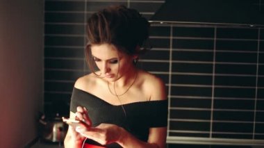 Güzel ve şık esmer kadın yazmaya mesaj aramak için telefon üzerinde.