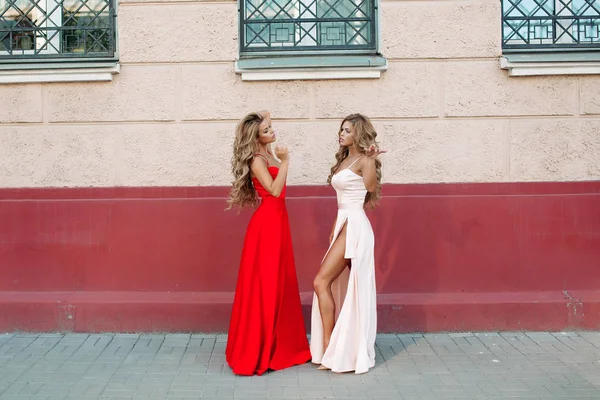 Привлекательные девушки в стильных платьях позируют перед камерой . — стоковое фото