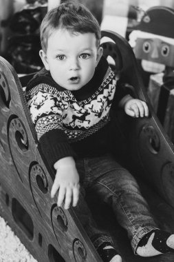 Küçük sarışın çocuk Noel ile oynarken sunar ve kutuları.