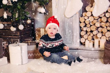 Küçük sarışın çocuk Noel ile oynarken sunar ve kutuları.