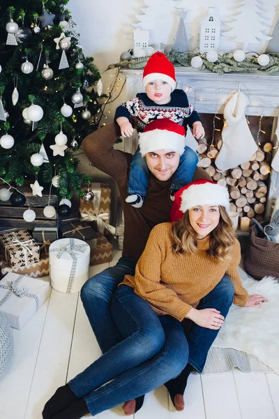 벽난로에 크리스마스 모자에서 행복 한 가족. — 스톡 사진