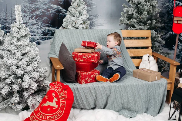 Anak kecil pirang bermain dengan hadiah Natal dan kotak . — Stok Foto