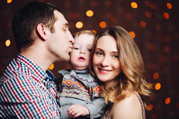 Retrato de familia feliz sentados juntos y posando durante la Navidad en el estudio —  Fotos de Stock