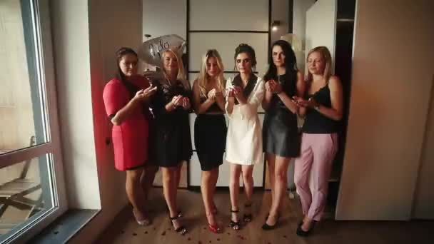 Les femmes à la mode s'amusent à l'hôtel, soufflant des confettis rouges à la caméra . — Video