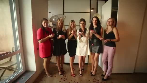 Modieuze vrouwen plezier in het hotel, rode confetti waait op camera. — Stockvideo