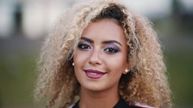 Işıklı saç ve kameraya bakarak ve gülümseyen makyaj ile mutlu hippi kız.