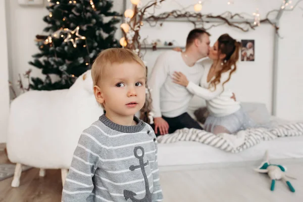 Lindo chico de pie en el estudio y mirando hacia otro lado durante la Navidad —  Fotos de Stock