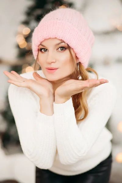 Härlig flicka i rosa ull mössa hatt gör luften kiss med händer. — Stockfoto