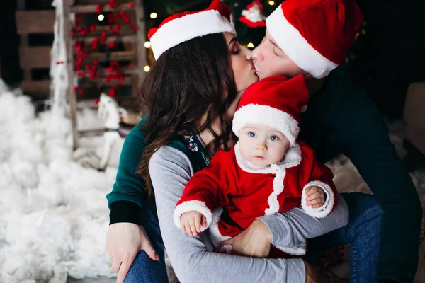 Familia feliz con un niño adorable divirtiéndose en el árbol de Navidad . —  Fotos de Stock