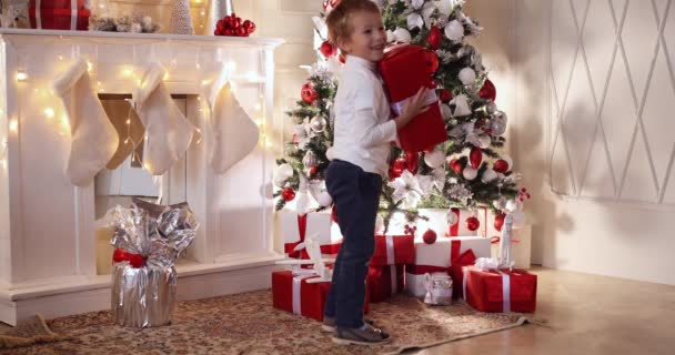 Kinderen met Kerstmis cadeautjes onder de kerstboom. — Stockvideo