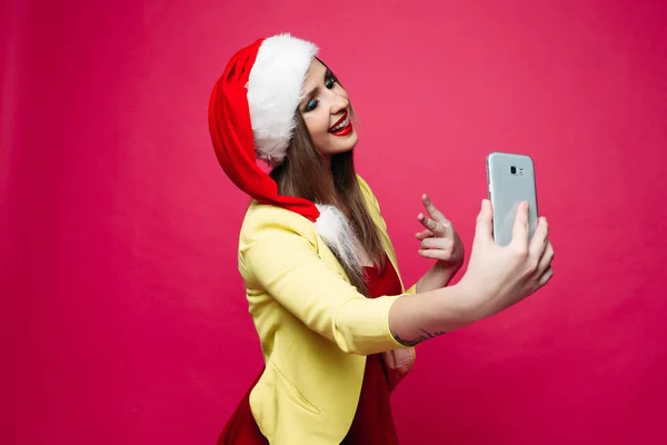 Surprised woman in santa hat making selfie over pink background. — Stock Photo, Image