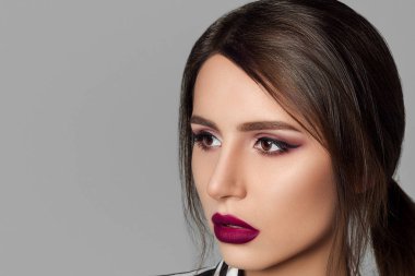 Parlak gece makyajlı, çizgili ceketli profesyonel bir model.