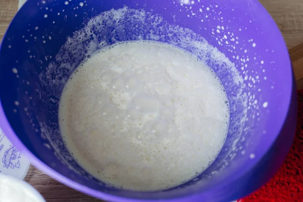 Pasta fatta in casa in grande piatto arrotondato per torte rosse in tavola . — Foto Stock