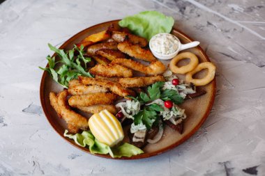 Kil tabak dolusu lezzetli appetizers.garlic sos, salata yaprakları ve peynir ile dekore edilmiş.