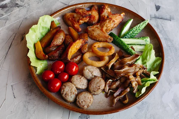 Clay plate full of delicious appetizers.garlic sauce, decorated with salad leaves and cheese. — Stock Photo, Image