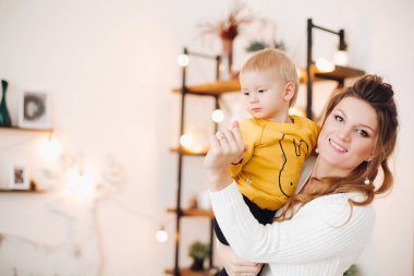 Bebeği kadar yükselen ve birbirlerine gülümseyen güzel annesi.