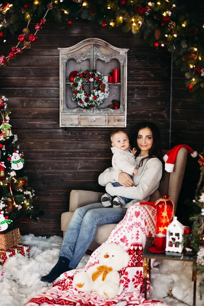 사랑 하는 크리스마스 나무에 대 한 아기와 함께 아름 다운 어머니. — 스톡 사진