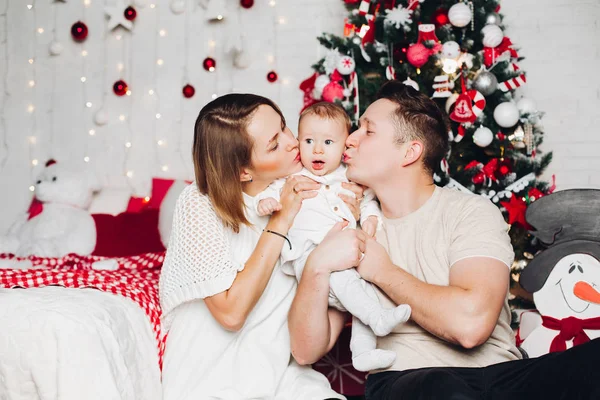 Kärleksfulla föräldrar med barn vid jul på inredda fir tree. — Stockfoto