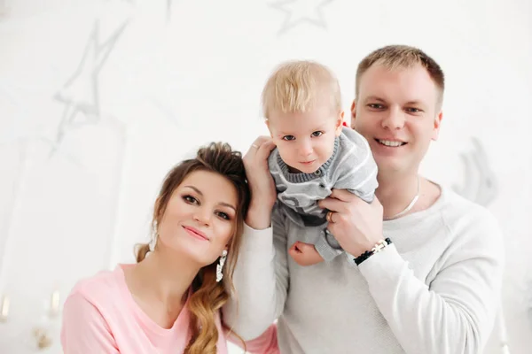 Pareja con hijo pequeño de pie y posando en el estudio de Navidad —  Fotos de Stock