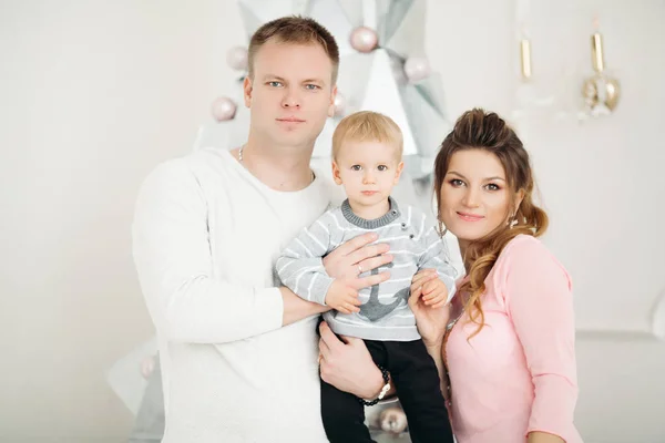 Par med lille son står och poserar i jul studio — Stockfoto