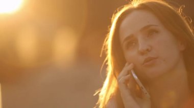 Çekici kadın parlak gün ışığı altında sohbet cep telefonu üzerinden.