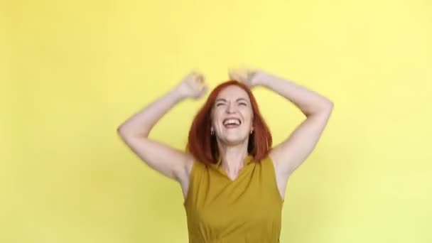 Känslomässiga flicka med rött hår skriker över gul bakgrund. — Stockvideo