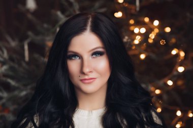 Noel için gülümseyen bir şekilde dekore edilmiş Studio esmer kadın.