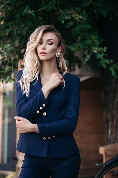 Mulher loira elegante em terno azul escuro com botões de ouro . — Fotografia de Stock