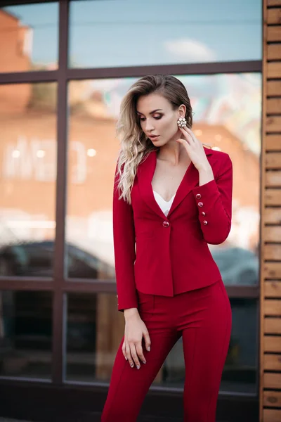 Mulher loira elegante em terno vermelho escuro com botões de ouro . — Fotografia de Stock