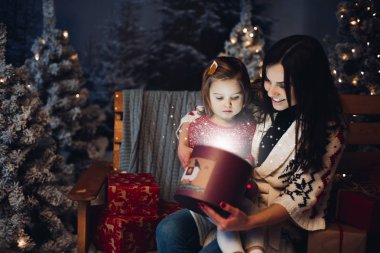 Sevgi dolu mutlu anne bebekle içinde Noel hediyesi arıyorum