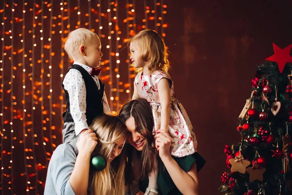 Dvě matky sedí s roztomilé děti vánoční dárky. — Stock fotografie