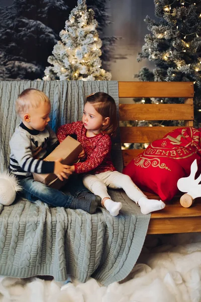 Dos niños pequeños jugando con Navidad cerca de la decoración y el árbol de Navidad . —  Fotos de Stock