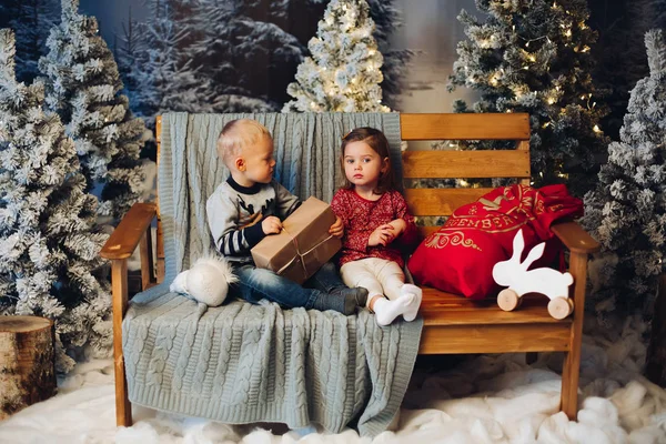 Двоє маленьких дітей грають з Різдвом біля прикрас та ялинки . — стокове фото
